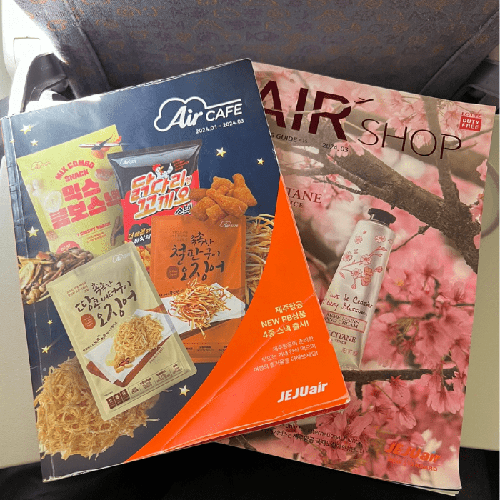 Jeju Air shopping and food magazine on tray table.