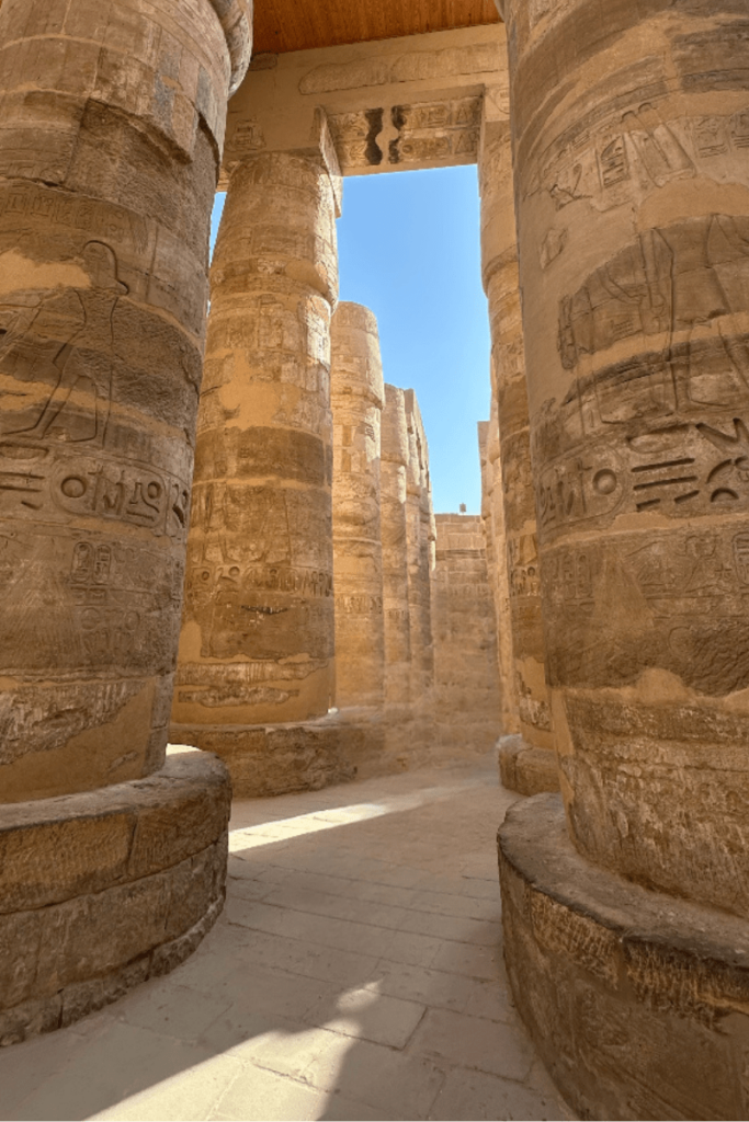 Visitors walking through the 134 columns of Karnak Temple's hypostyle hall